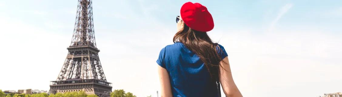 Woman in red beret admiring the iconic Eiffel Tower from Trocadéro gardens in Paris