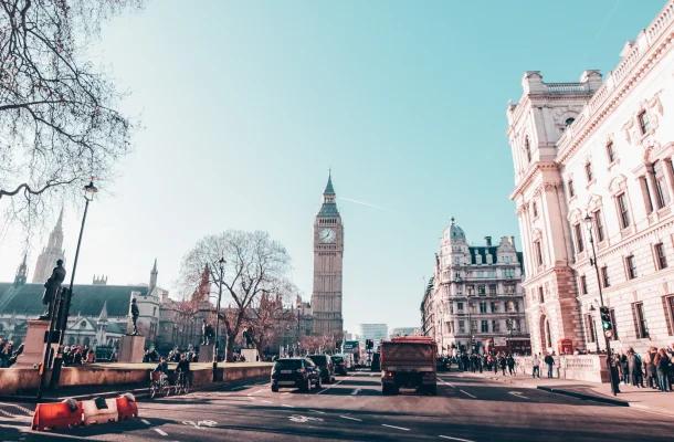 Big Ben clock tower and Westminster architecture in London with busy street traffic and pedestrians
