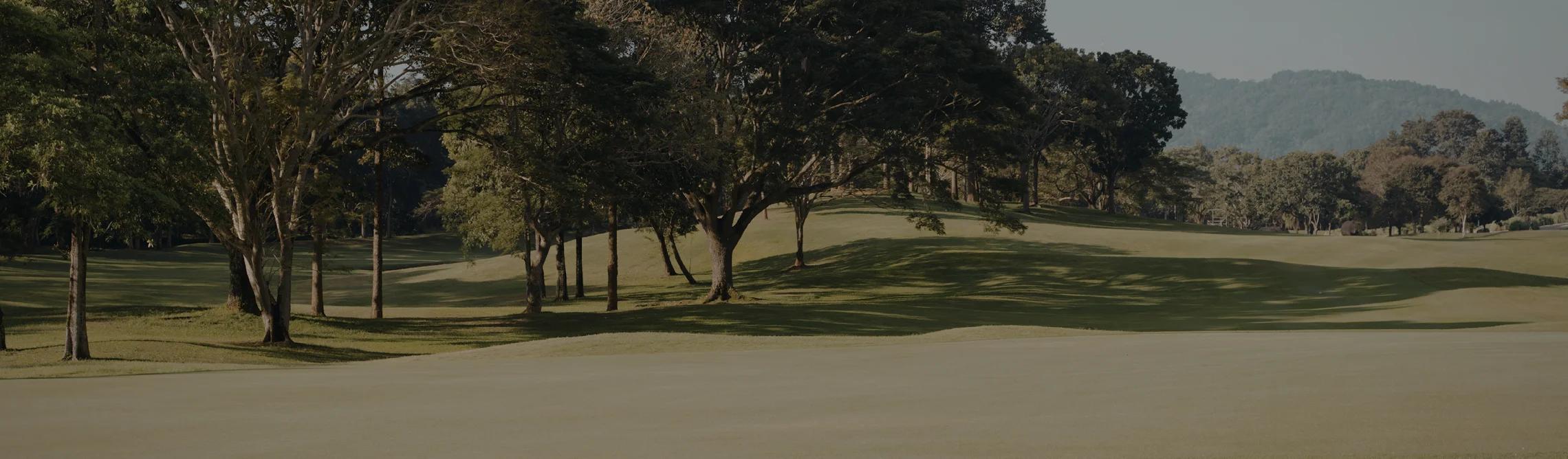 Pristine Pinehurst golf course with rolling fairways, mature trees, and mountain backdrop for luxury travel