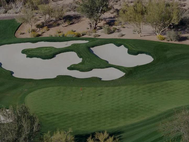 Pristine desert golf course in Scottsdale with manicured greens, sand bunkers and desert landscape
