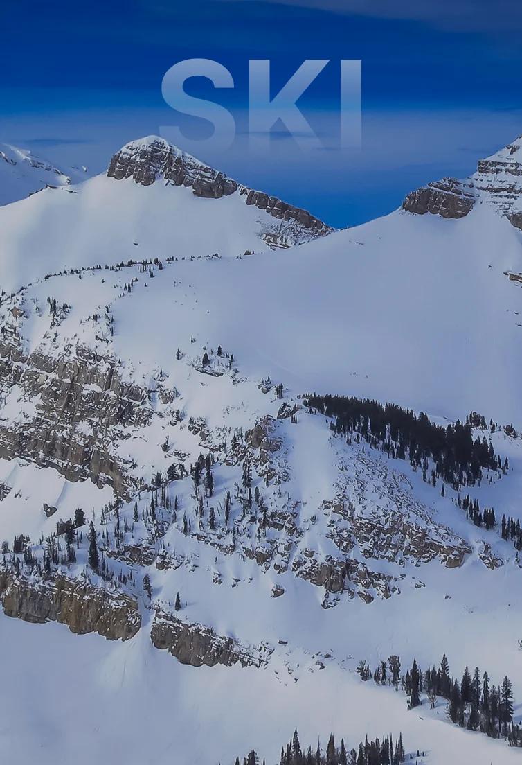 Snow-covered mountain peaks and pristine alpine slopes under brilliant blue skies in Jackson Hole