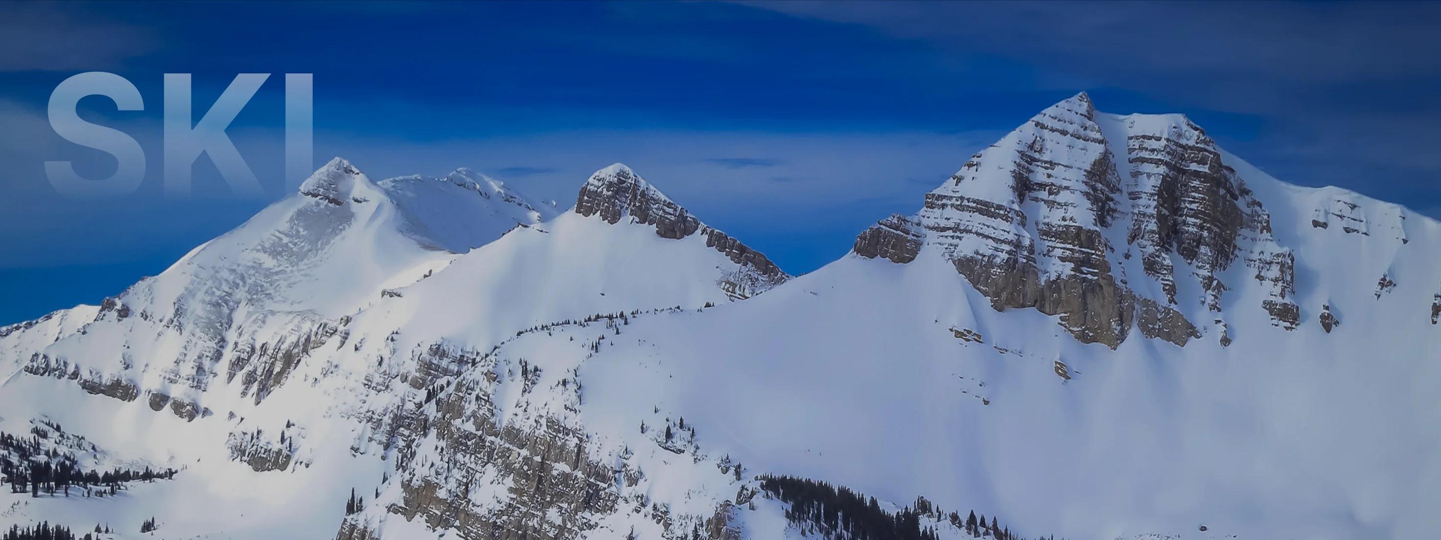 Snow-covered mountain peaks and pristine alpine slopes under brilliant blue skies in Jackson Hole