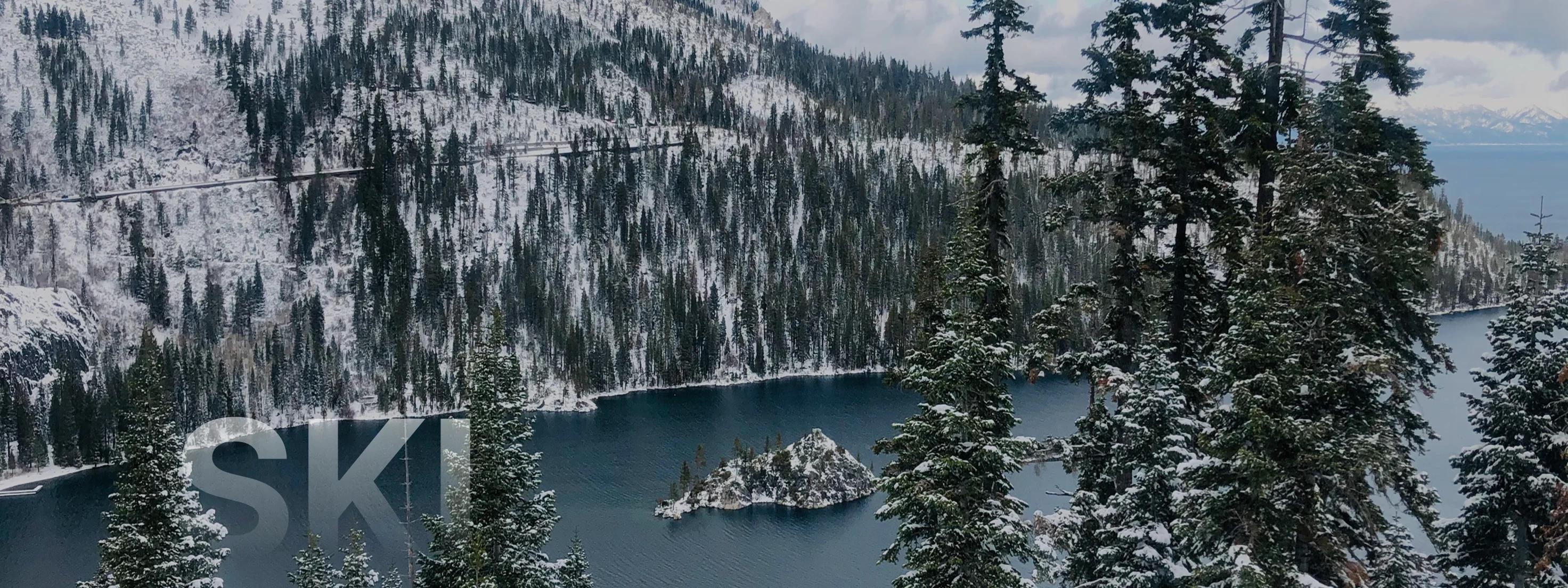 Snow-covered alpine lake surrounded by evergreen forests and mountain peaks in Lake Tahoe winter landscape