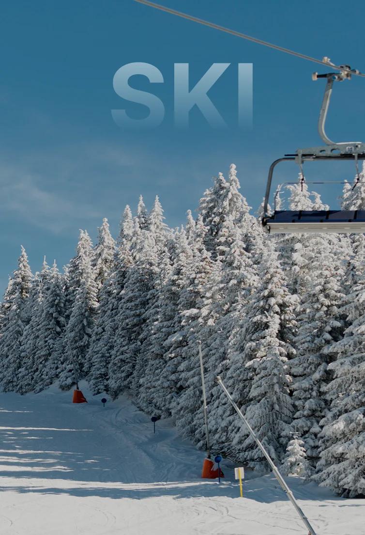 Pristine ski slopes lined with snow-covered evergreen trees and chairlift at Park City resort