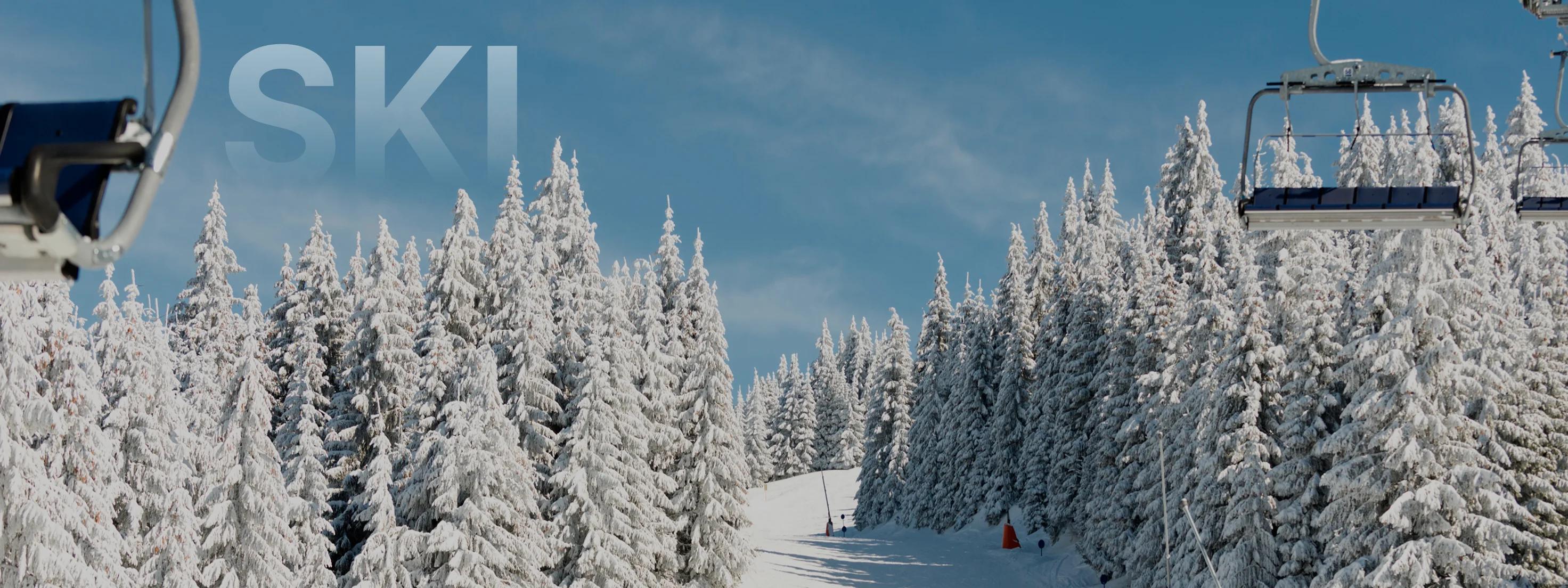 Pristine ski slopes lined with snow-covered evergreen trees and chairlift at Park City resort