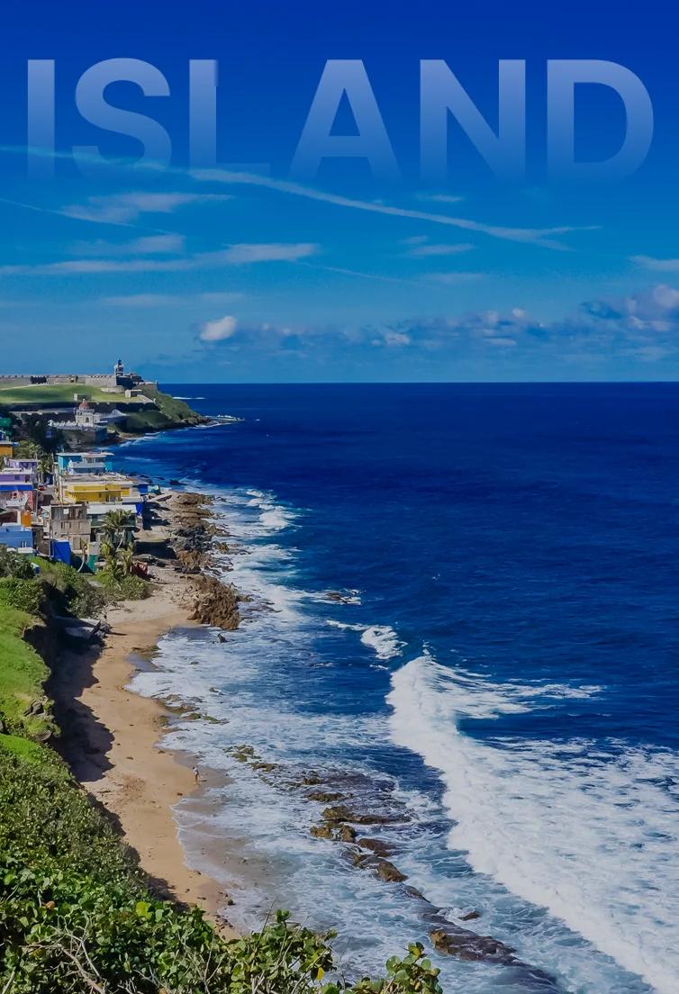 Aerial view of San Juan's historic coastline with colorful colonial buildings, ancient fort walls, and pristine beaches meeting azure Caribbean waters