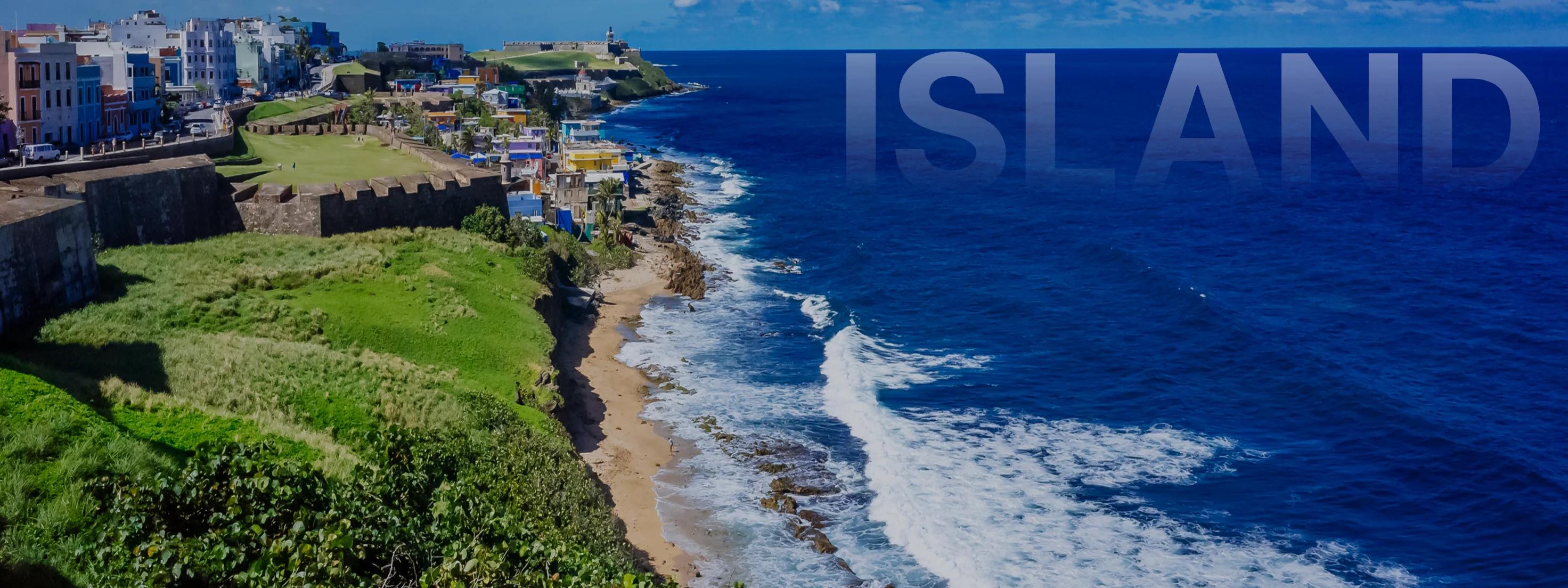 Aerial view of San Juan's historic coastline with colorful colonial buildings, ancient fort walls, and pristine beaches meeting azure Caribbean waters