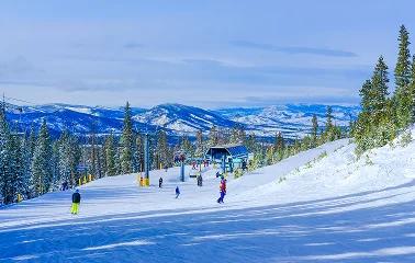 Pristine ski slopes at Vail with skiers descending powdery runs surrounded by snow-covered mountains