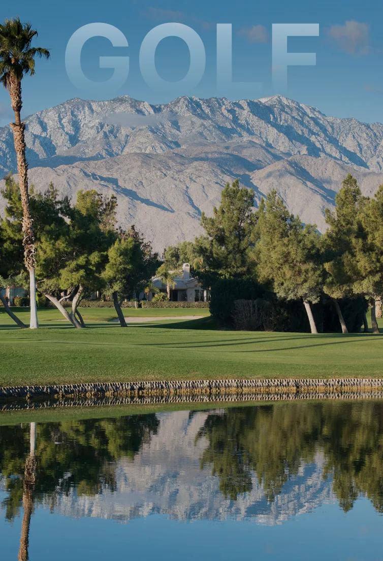 Pristine golf course with manicured greens and palm trees against dramatic snow-capped mountains in Palm Springs