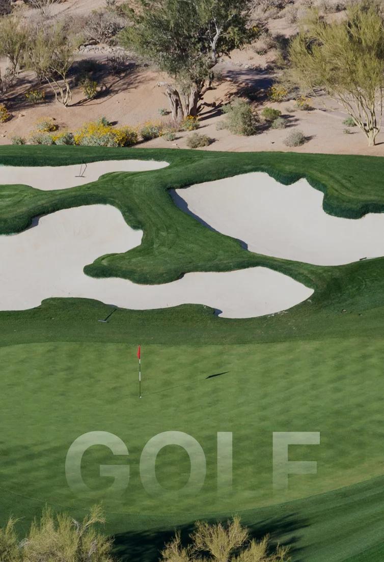 Aerial view of pristine Scottsdale golf course with manicured greens, sand bunkers and desert landscape