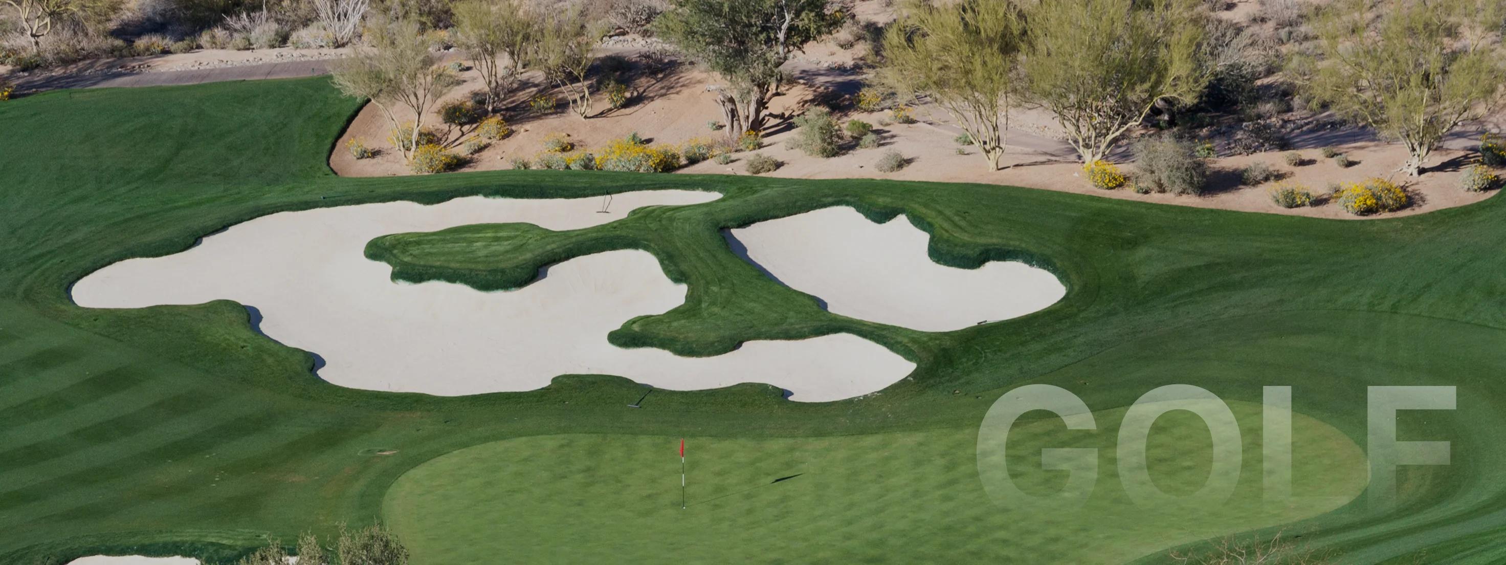 Aerial view of pristine Scottsdale golf course with manicured greens, sand bunkers and desert landscape