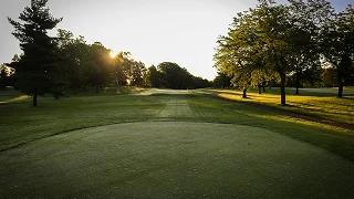 Pristine golf course fairway at sunrise with manicured greens and tree-lined holes in Palm Beach