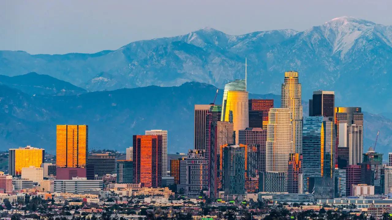Downtown Los Angeles skyline with snow-capped mountains backdrop showcasing premium destination for luxury jet travel