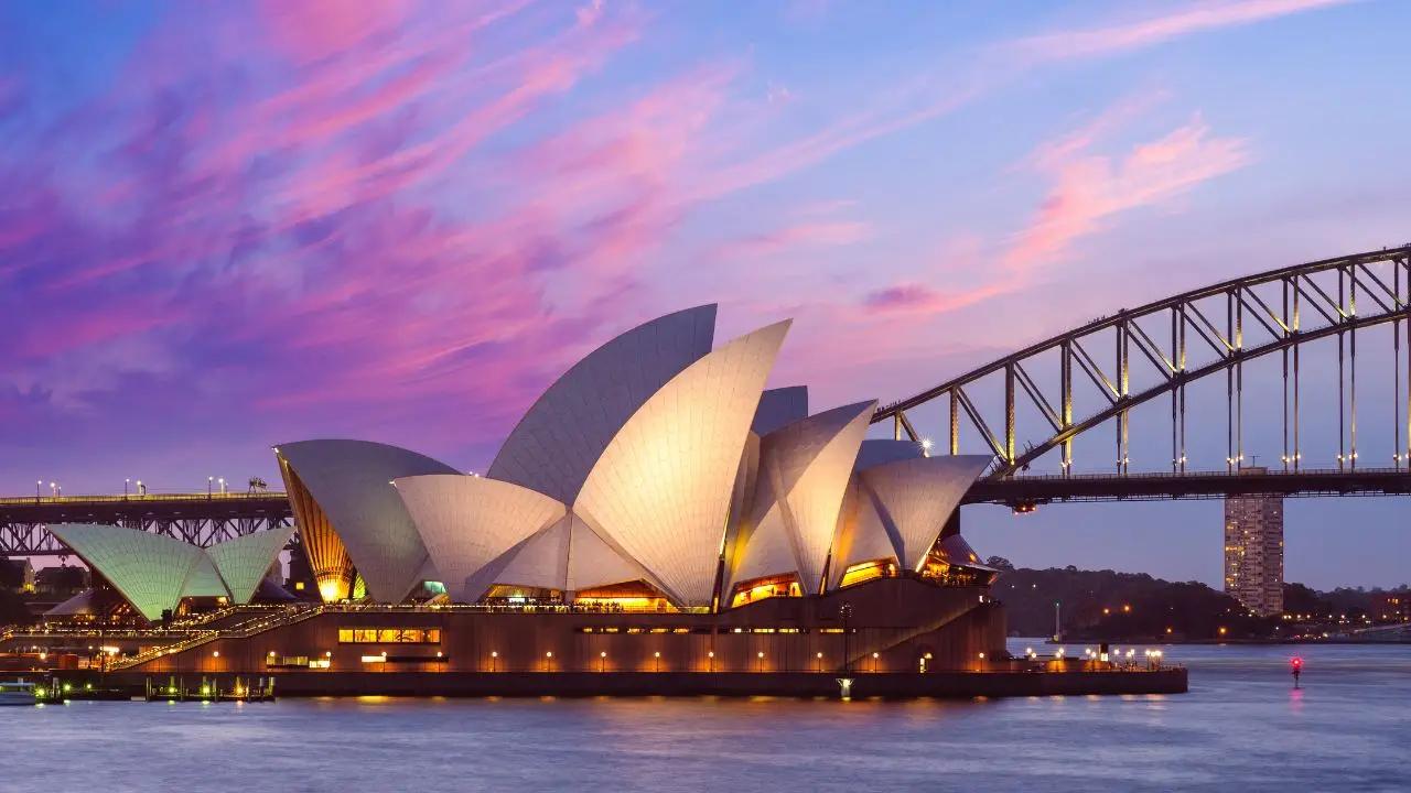 Sydney Opera House and Harbour Bridge illuminated at sunset, showcasing premium destination for luxury jet travel